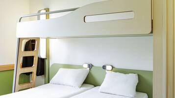 A bunk bed with a ladder, two pillows, and bedside tables with lights.