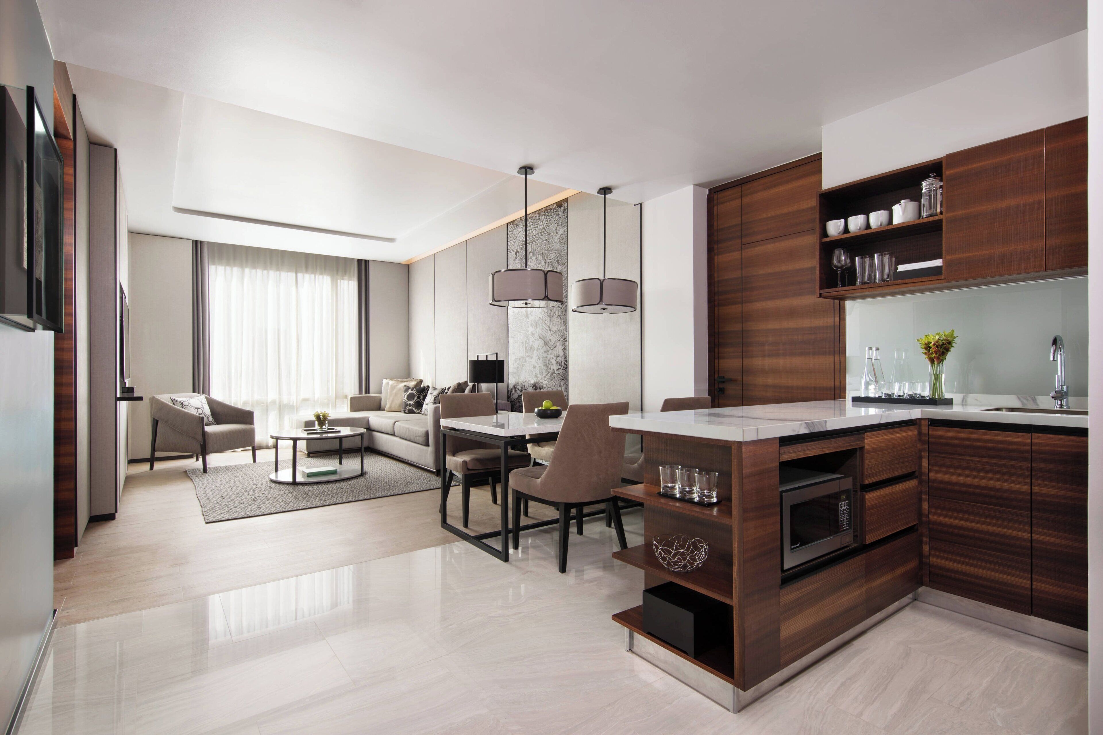 A modern kitchen with dark wood cabinets, a marble countertop, and a built-in oven.