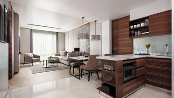 A modern kitchen with dark wood cabinets, a marble countertop, and a built-in oven.