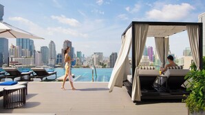 A rooftop pool area with lounge chairs, a cabana, and a city skyline view. - Bangkok Marriott Hotel The Surawongse (Bangkok)