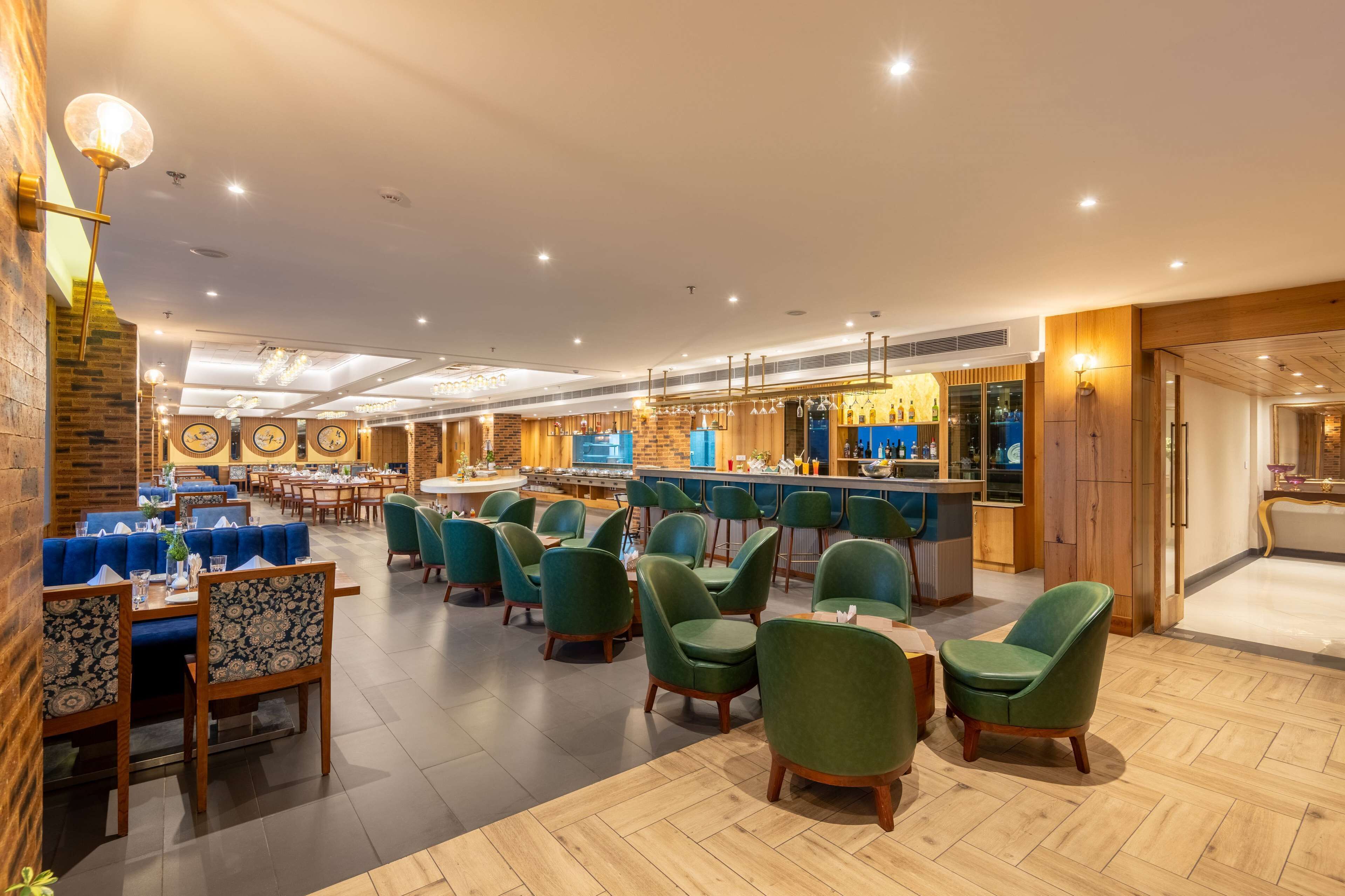A spacious hotel lobby with multiple seating areas, a bar, and a reception desk.