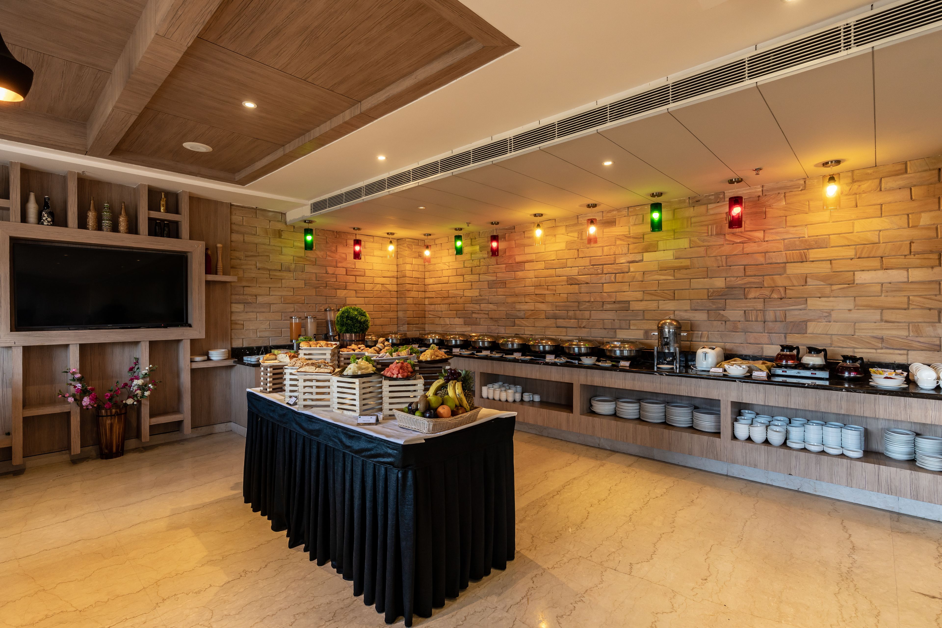 A buffet setup with various food items and a television on the left.