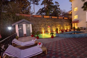 Una piscina al aire libre, sillones reclinables de piscina