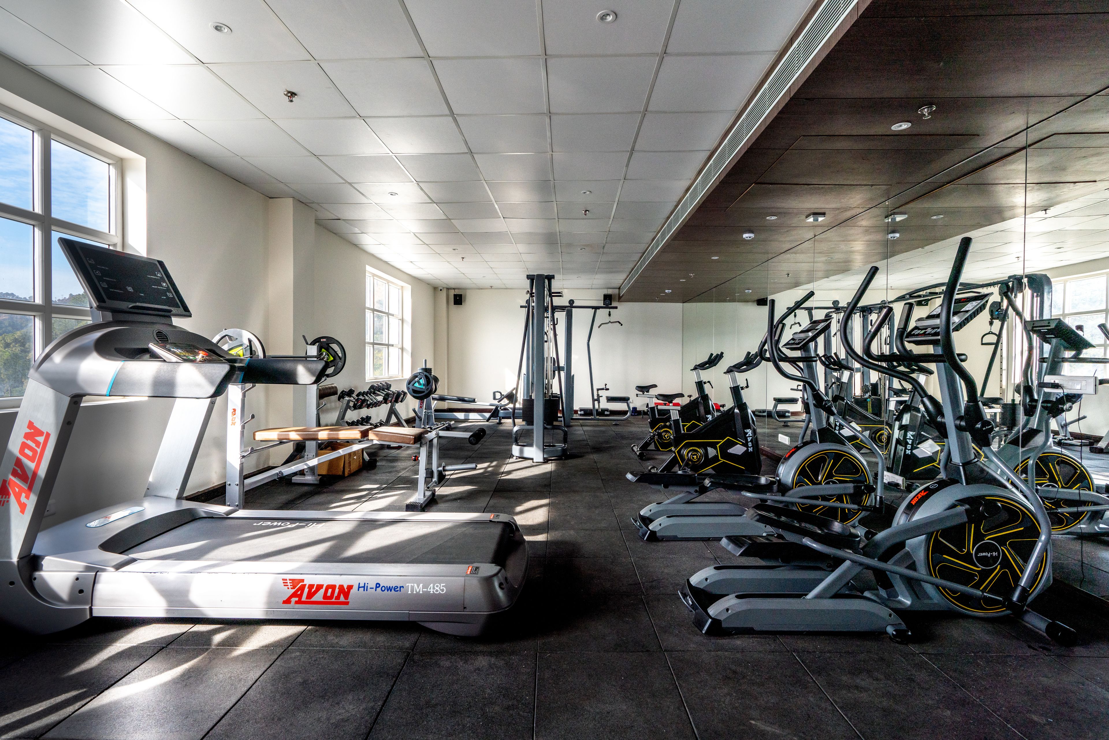 Une salle de sport équipée de tapis de course, de vélos d’appartement et d’appareils de musculation.