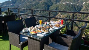 Ein Esstisch mit Frühstücksgebäck und Blick auf die Berge.