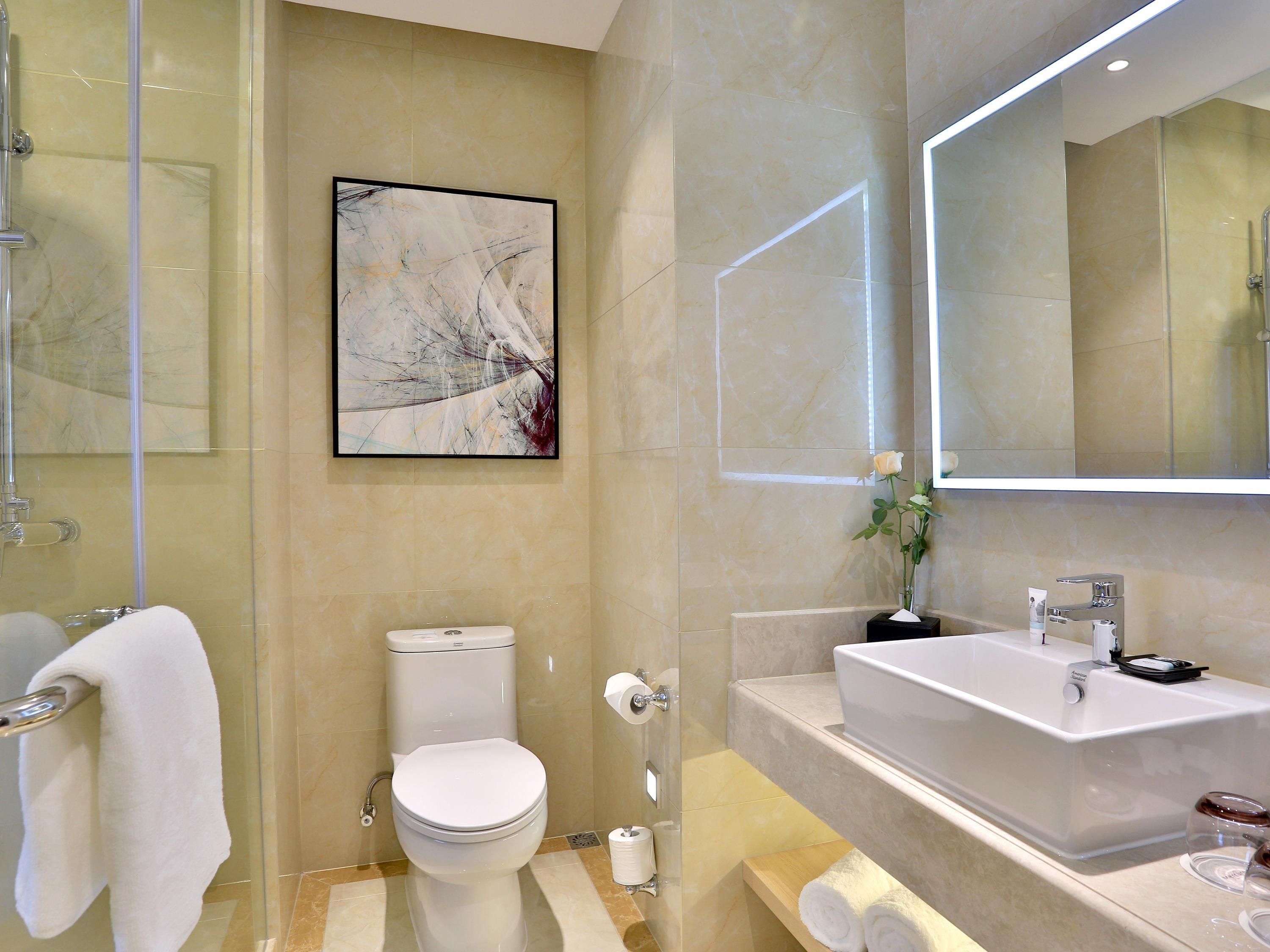 Une salle de bain moderne équipée de toilettes, d’un lavabo et d’une douche.