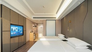 A hotel room with a large bed, a TV mounted on the wall, a desk with a chair, and a wardrobe. - Mercure Hangzhou Linping Hotel (Hangzhou)