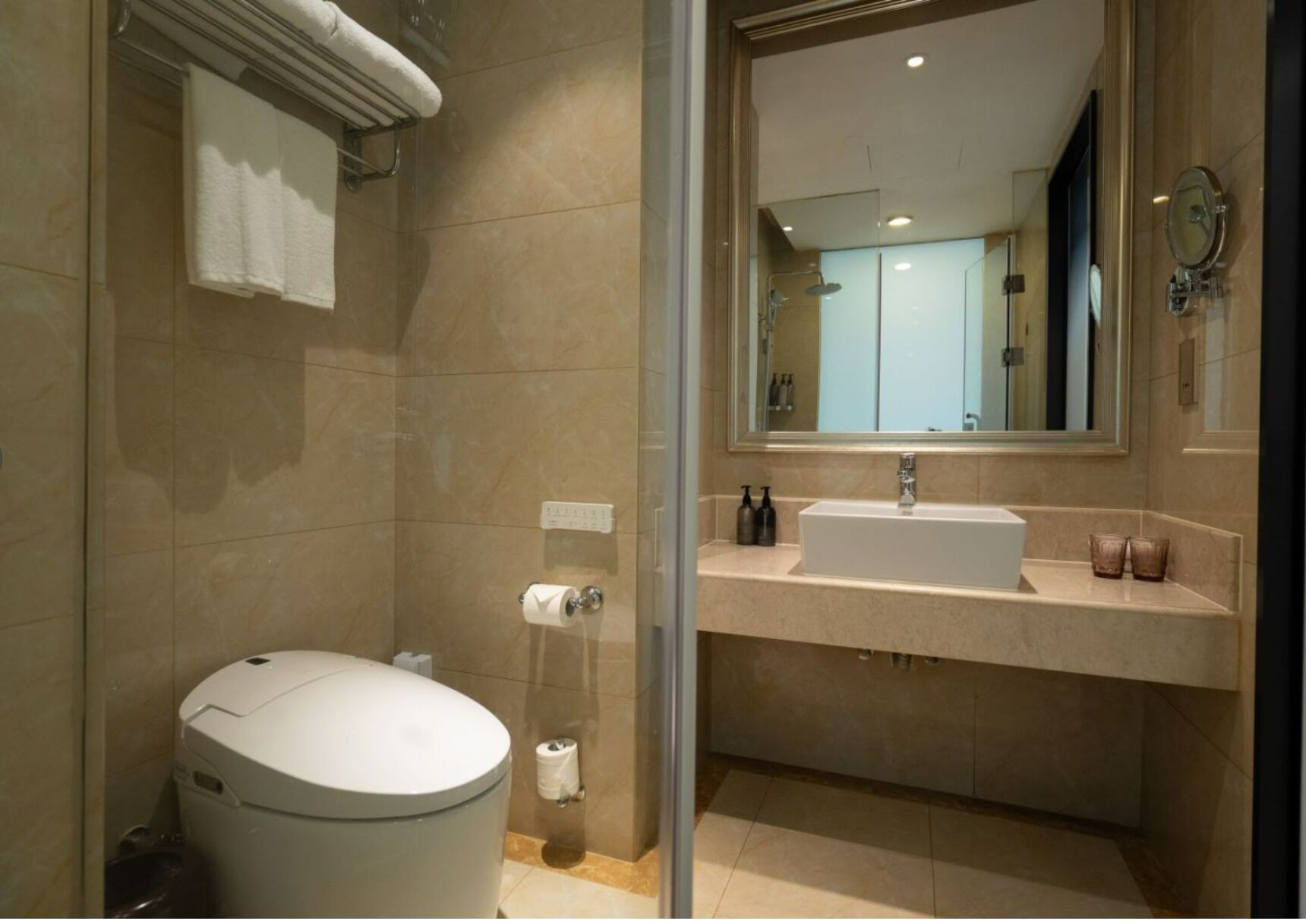 A modern bathroom with a toilet, a sink, and a mirror.