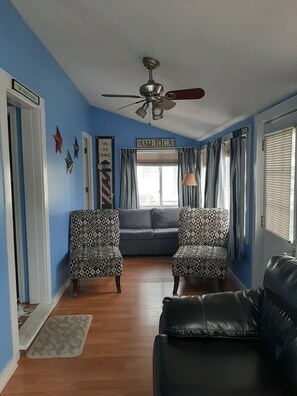 A living room with a blue wall, a ceiling fan, a grey sofa, patterned armchairs, and a black leather couch. - Q St. Less traffic!!! Gas grill.
Rare find. Five bedroom with fenced in yard! (Hampton)
