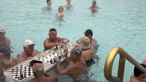 Mensen spelen schaak in een zwembad.