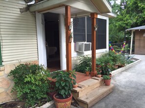 Step up to a charming entrance with a cozy porch, complete with potted plants and a welcoming window.