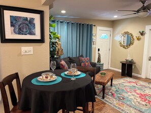 Un coin repas comprenant une table ronde, des chaises et un tapis décoratif.