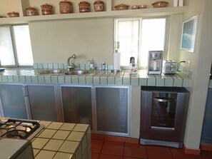 A kitchen with a gas stove, two sinks, a coffee maker, and a toaster. - Villa  Europa - A Modern Private Home - Enjoy Views, Downtown and Beaches (Puerto Vallarta)