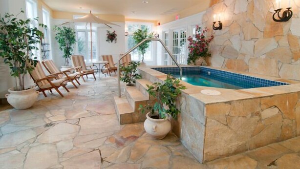 A spa area with a stone pool, lounge chairs, and potted plants. - HILTON GVC NEW YEAR'S 2026-27 - 6 Nights (Mont-Tremblant)