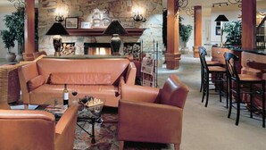 A spacious lounge area with leather sofas, a fireplace, and a bar with wooden chairs. - HILTON GVC NEW YEAR'S 2026-27 - 6 Nights (Mont-Tremblant)