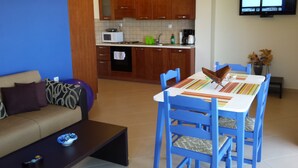 Una sala de estar moderna con sofá, mesa de centro y comedor con sillas y una mesa.