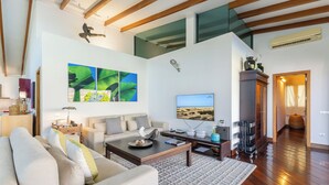 A spacious living room with a sofa, coffee table, and artwork on the walls. - Villa La Canela by VillaGranCanaria (San Bartolomé de Tirajana)