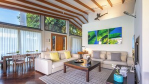 A spacious living area with a wooden ceiling, a sofa set, a coffee table, and a TV. - Villa La Canela by VillaGranCanaria (San Bartolomé de Tirajana)