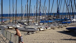 Ein Strand mit vielen vor Anker liegenden Segelbooten.