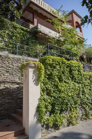 Uma escadaria de pedra que leva a um edifício com varanda.