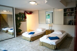 A hotel room with two single beds, a large mirror, a bookshelf, and a staircase leading to an upper floor. -    Superb 5* family  Villa  for up to10 people (Ajaccio)