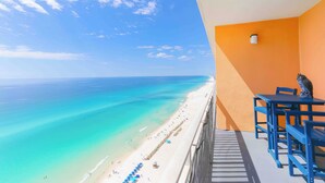 Un balcon avec vue sur une plage et l’océan.