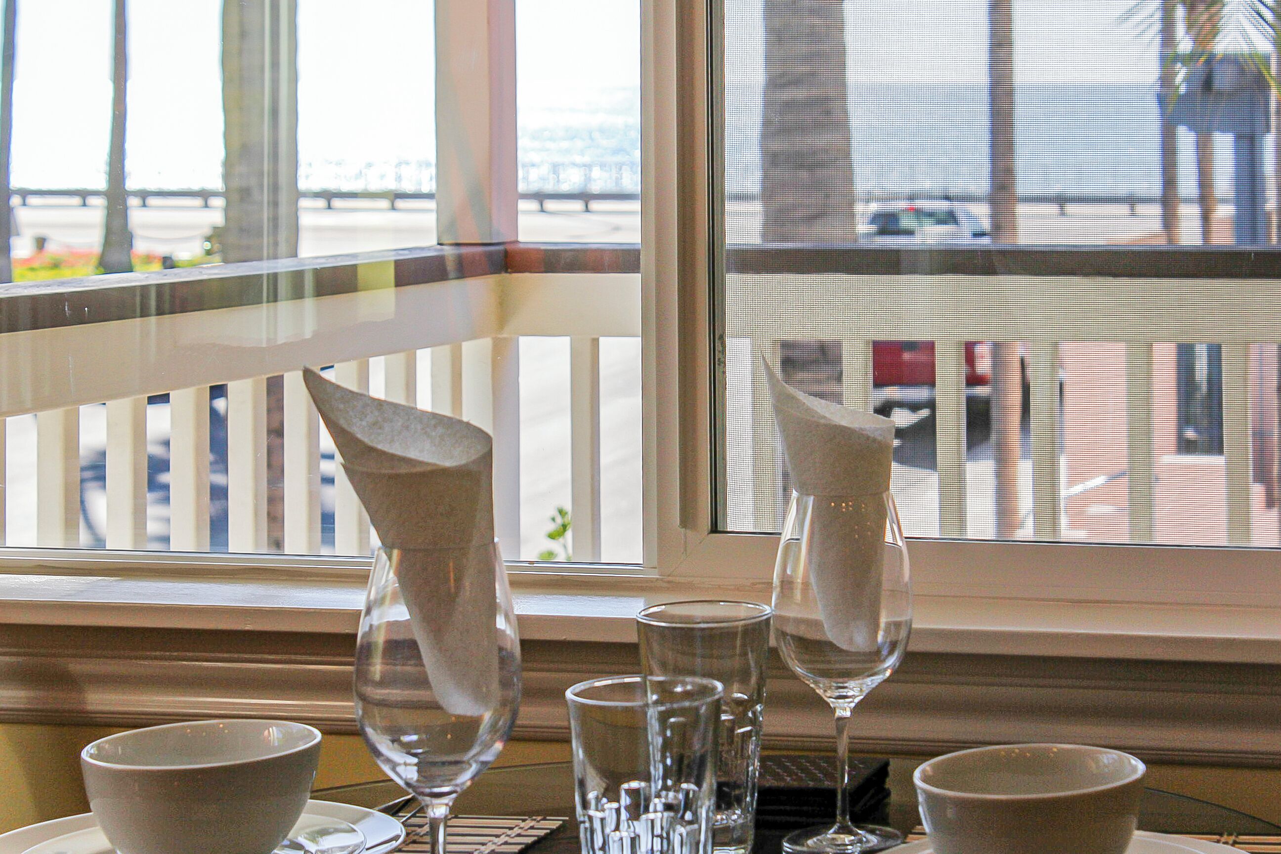 A table with a bowl, a wine glass, and a water glass.