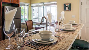 Une cuisine dotée d’un plan de travail en marbre, d’un réfrigérateur et d’un coin repas avec une table et des chaises.