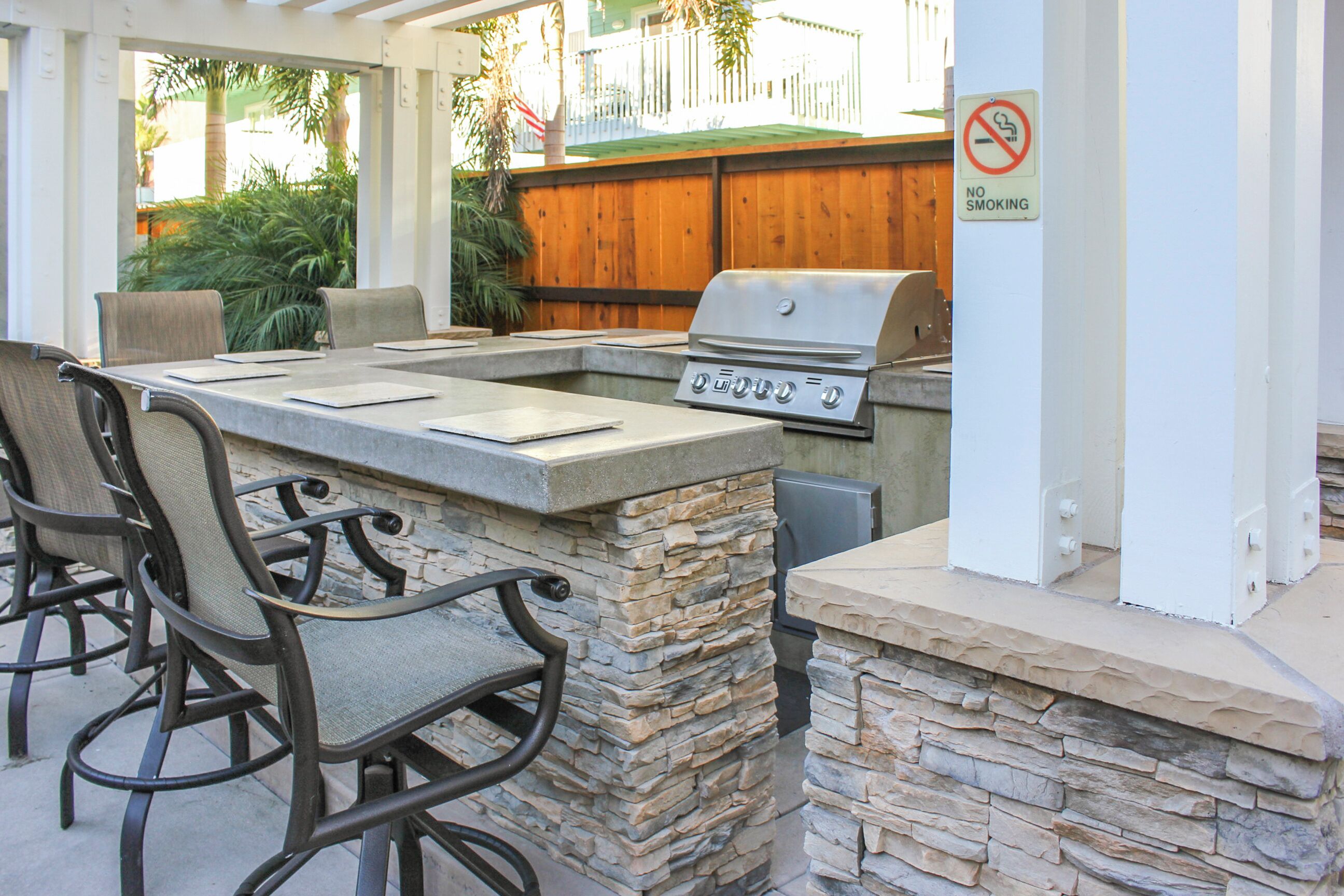 An outdoor patio with a stone barbecue and seating.