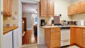 A kitchen with wooden cabinets, a stove, a microwave, and a refrigerator.