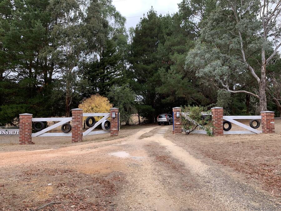 A gated entrance with a dirt path leading to a building labeled "ENS HUT".