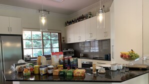 Una cocina moderna con una isla central, electrodomésticos de acero inoxidable y una variedad de alimentos y utensilios de cocina.