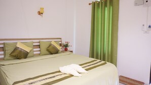 Una cama bien hecha con una colcha a rayas, almohadas y una toalla doblada.