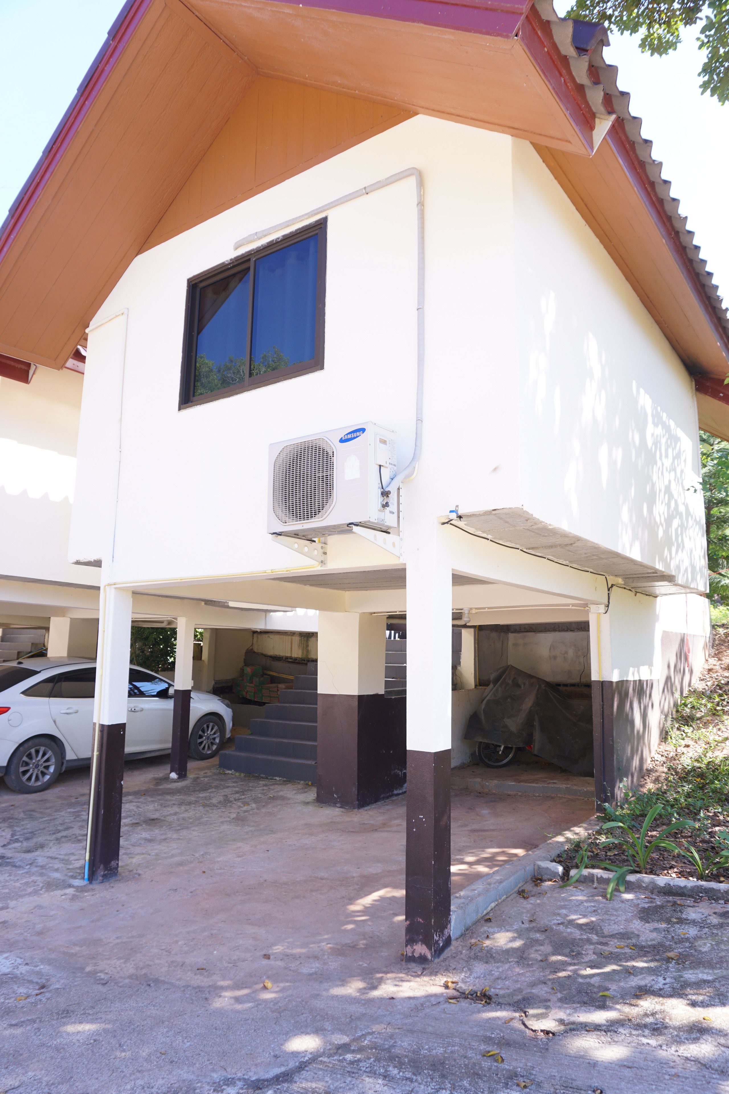 Uma casa de dois andares com garagem coberta e fachada branca.