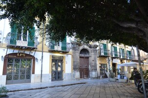 Calle con edificios, incluyendo una tienda con el rótulo 'LPS' y otra con el rótulo 'Garrapino'.