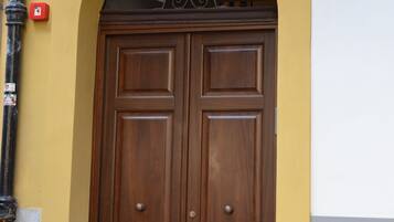 A double wooden door with a decorative arch above it.