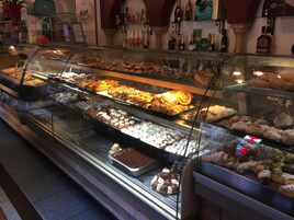 Una vitrina de pastelería con diversos pasteles y postres.