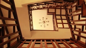 A wooden staircase with a geometric design and a central light fixture. - Tokha Holiday Home (Tohka)