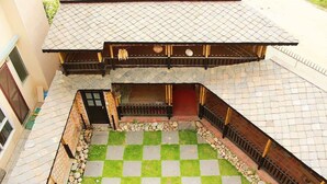 A traditional Japanese-style building with a tiled roof and a checkered stone courtyard. - Tokha Holiday Home (Tohka)