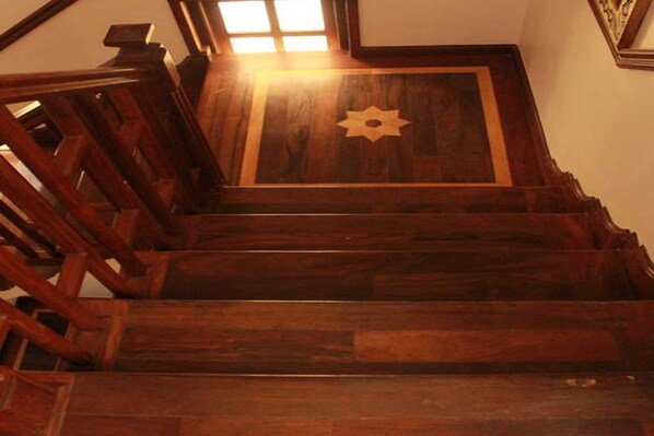 A wooden staircase with a decorative panel at the top.