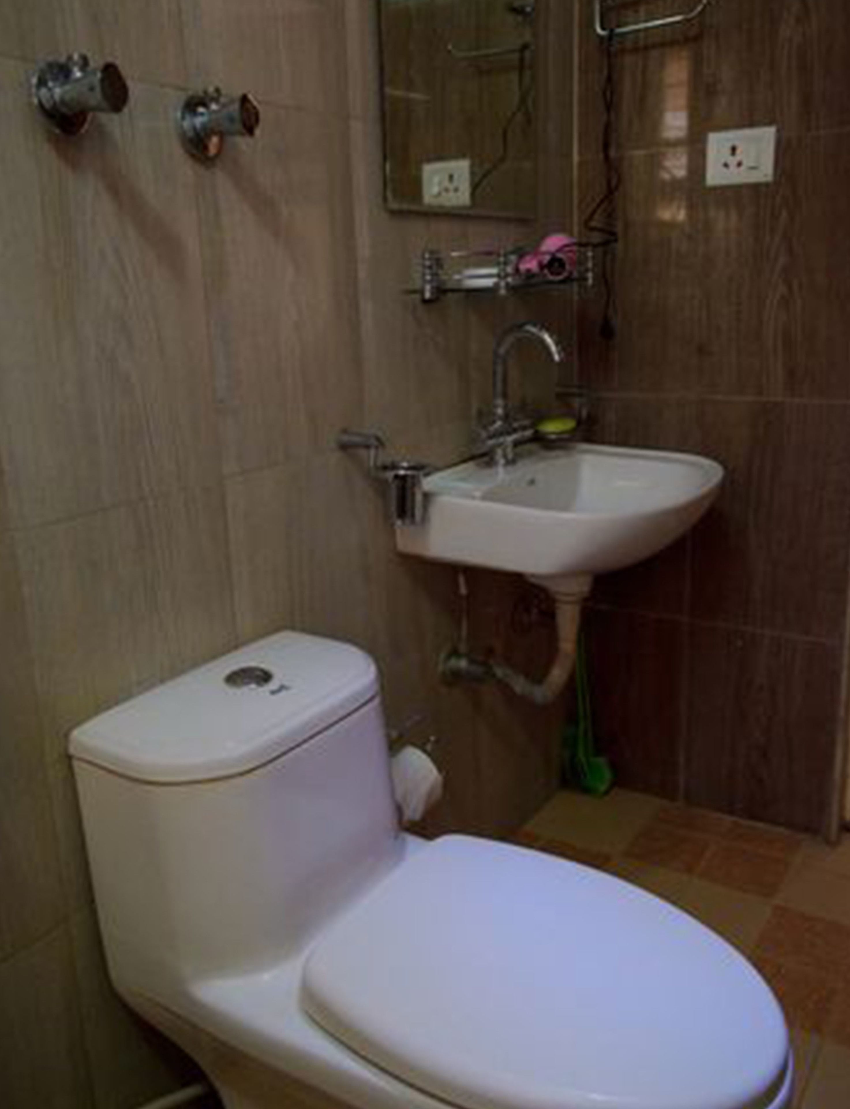 Un baño con inodoro, lavamanos y espejo.