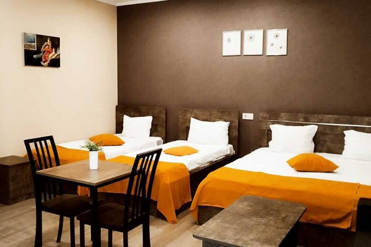 A hotel room with two beds, a desk, and a wardrobe.
