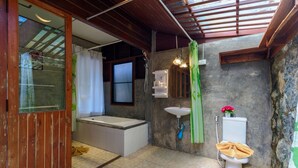 A bathroom with a bathtub, toilet, and sink. - Kanya Cozy Bungalows Kata Beach (Karon)