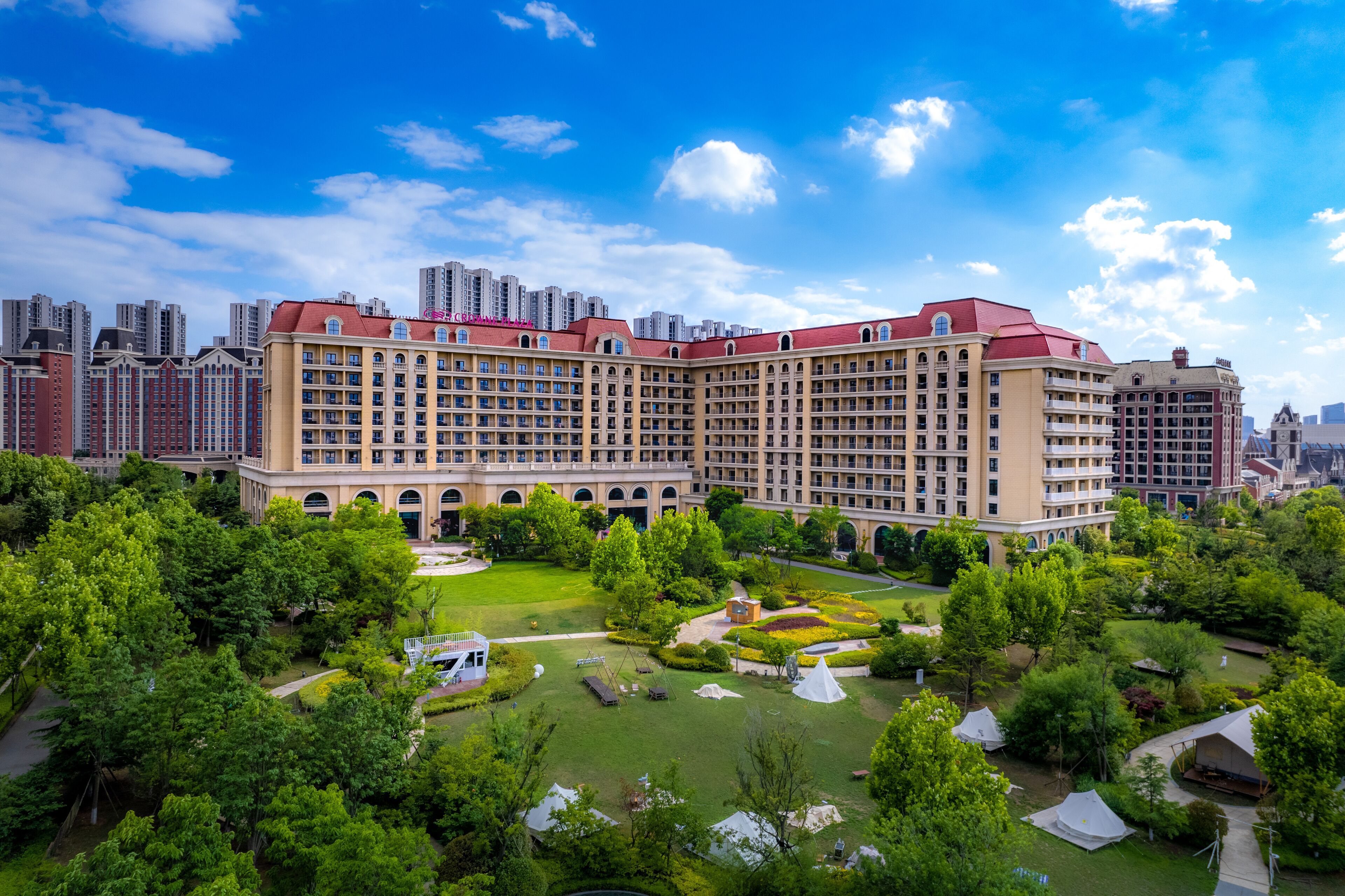 A large hotel with multiple floors and a central courtyard with greenery and seating areas.