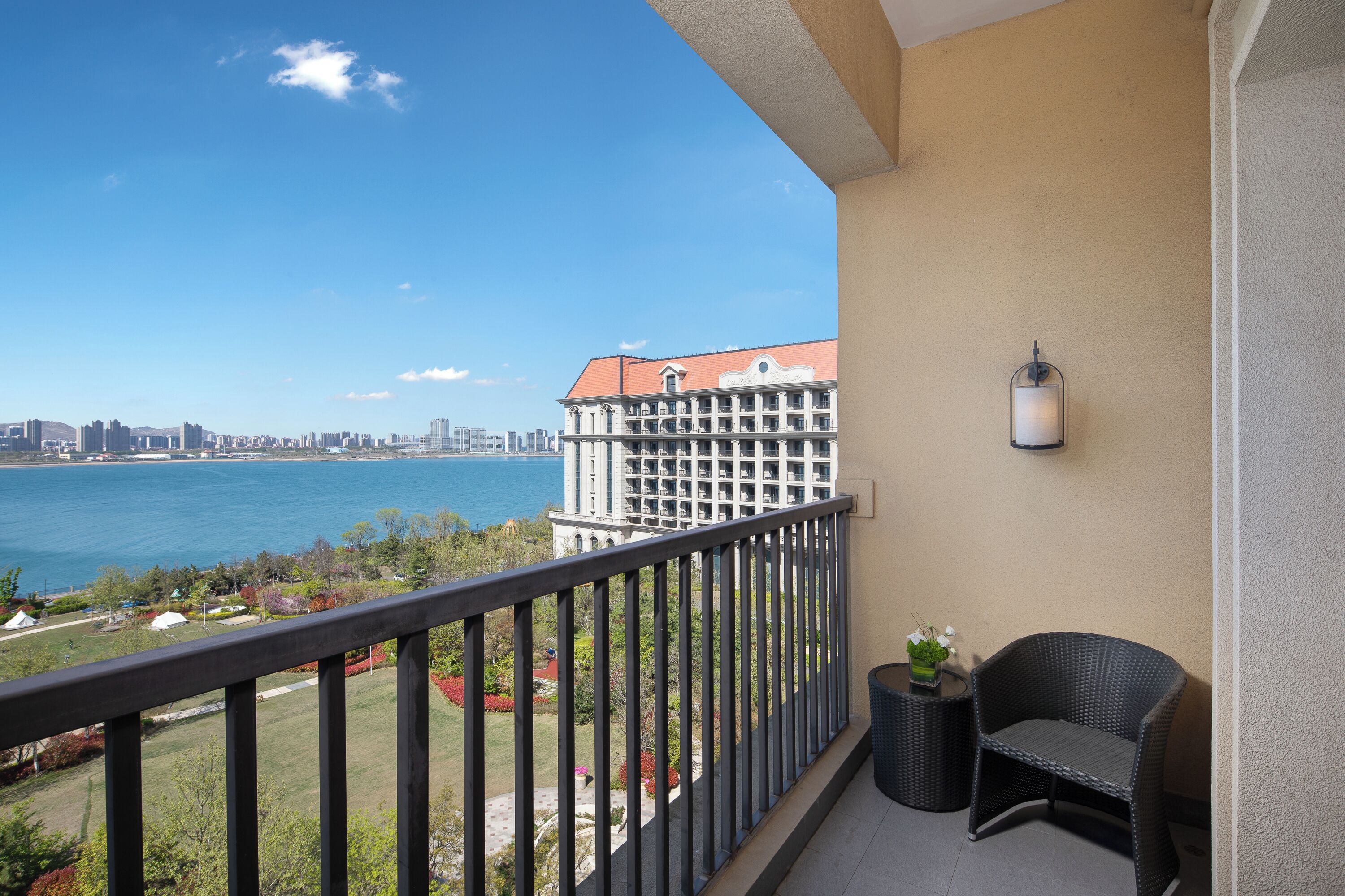A balcony with a view of a body of water and a city skyline.
