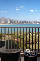 Un balcón con vista a un horizonte urbano y una masa de agua.