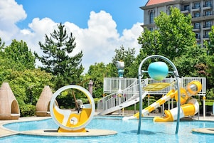 Una piscina con toboganes de agua y un parque infantil.