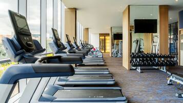 A gym with treadmills, weights, and exercise equipment.