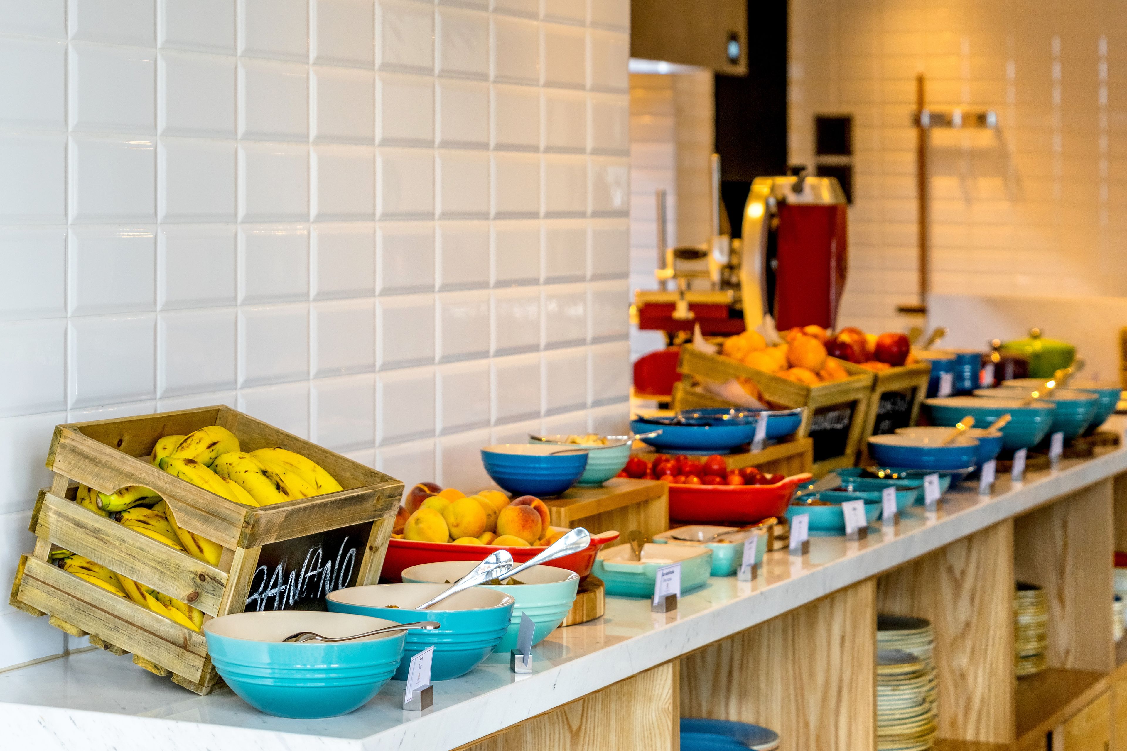 Un buffet proposant divers plats et fruits, notamment des bananes et des citrons.