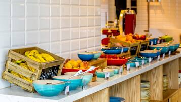 Un buffet proposant divers plats et fruits, notamment des bananes et des citrons.